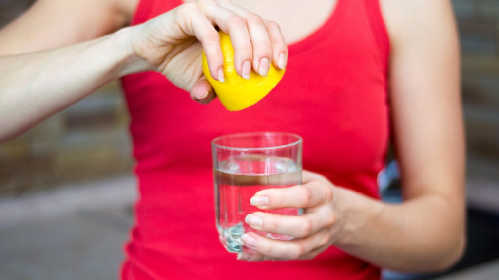 Woman squeezing lemon in her water