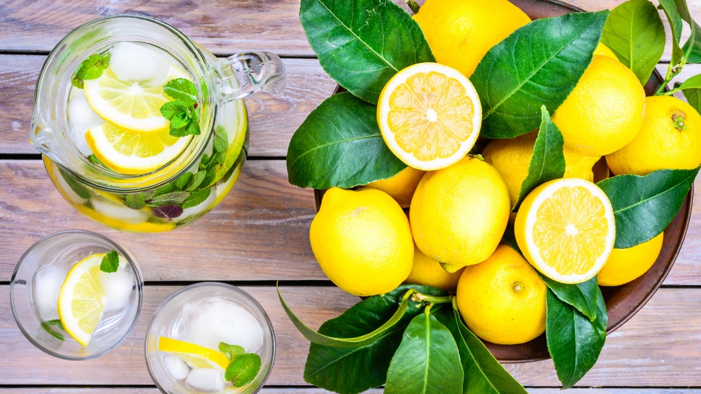 Fresh lemons and a pitcher of lemon water