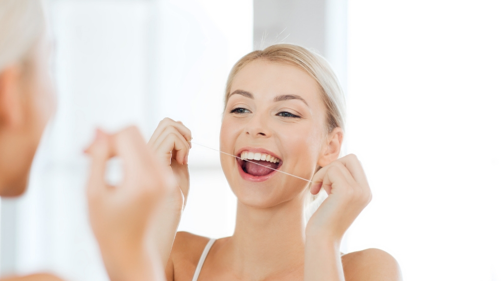 Woman flossing her teeth