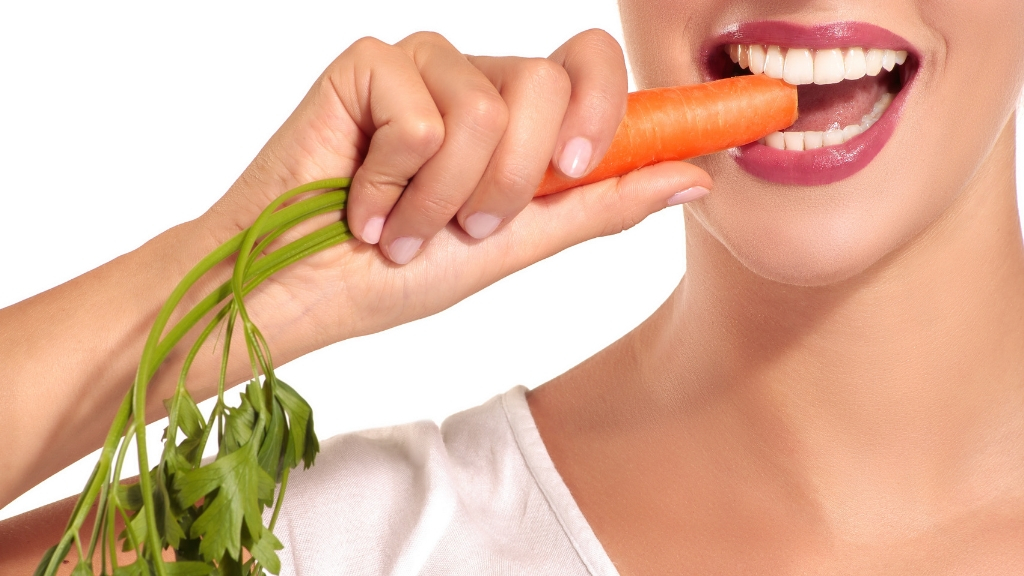 Woman eating carrot