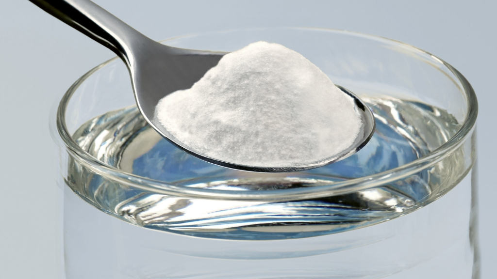 a spoonful of baking soda about to be mixed with water