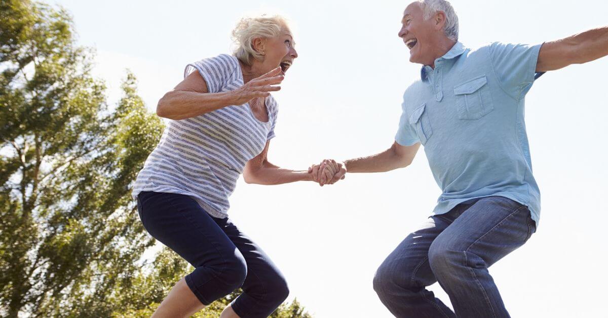 a senior couple jumping joyfully