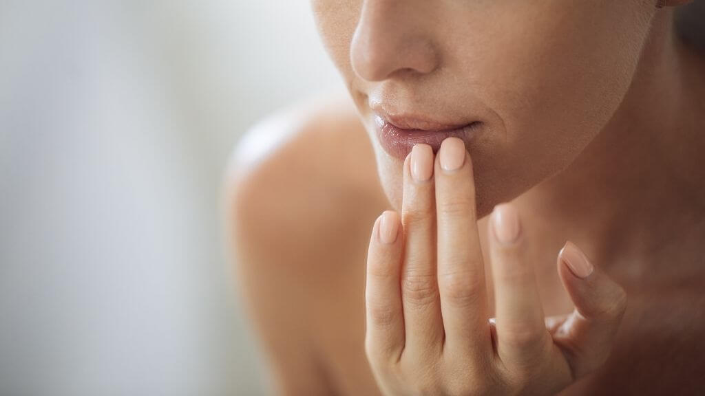 Woman putting lip balm