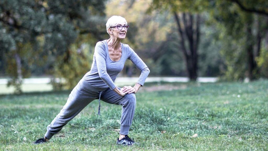 Senior woman stretching in the park