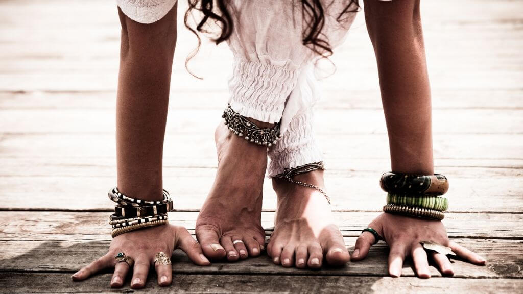 Woman with bracelets and anklets stretching