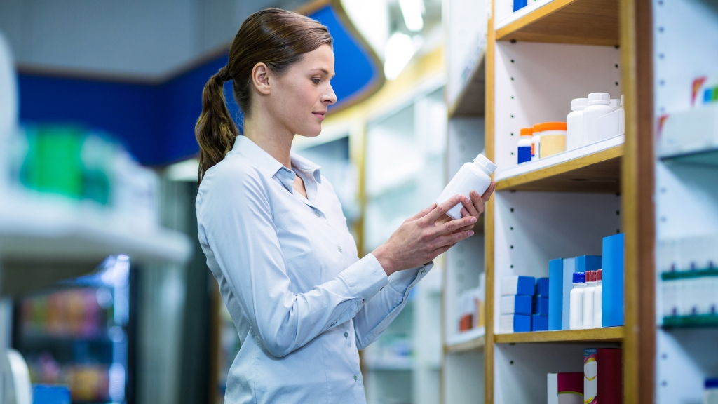 Woman reading supplement facts on a bottle