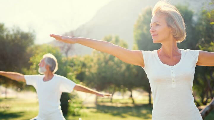 couple doing yoga out in the nature