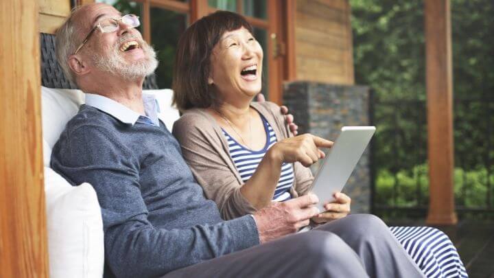 Elderly couple laughing at their porch