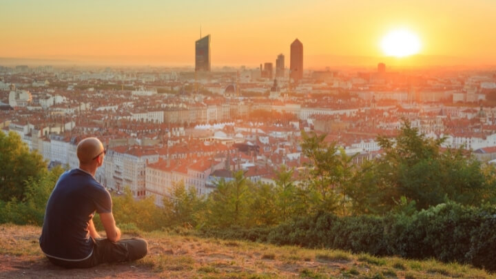 A man watching the sunset over the city