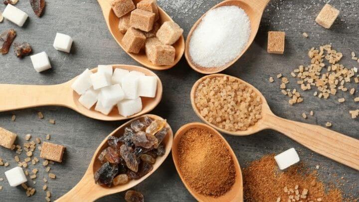 Different types of sugar in wooden spoons