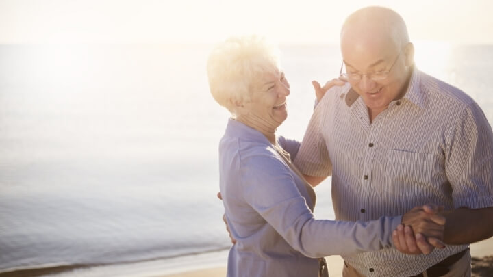 A senior couple dancing by the sea