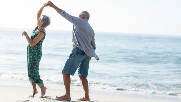 A senior couple dancing on the beach