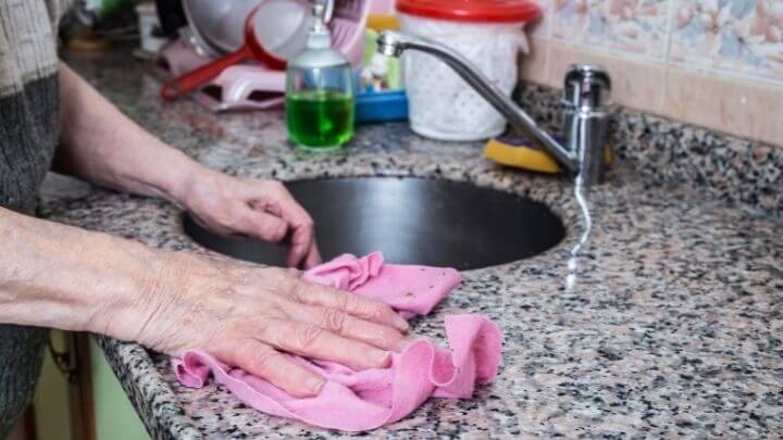 Woman cleaning the kitchen with a soft rag