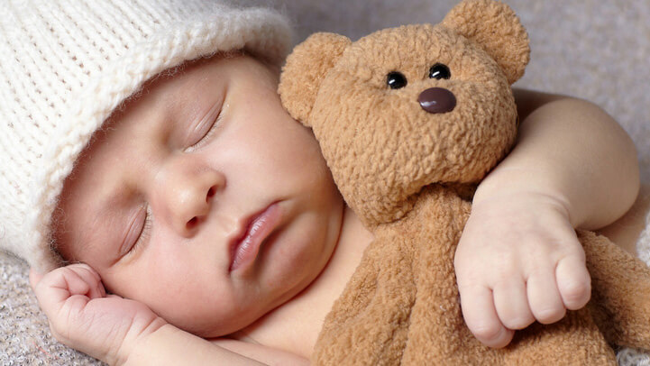 Baby sleeping with a teddy bear