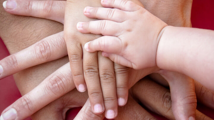 The right hands of a family of four on top of each other