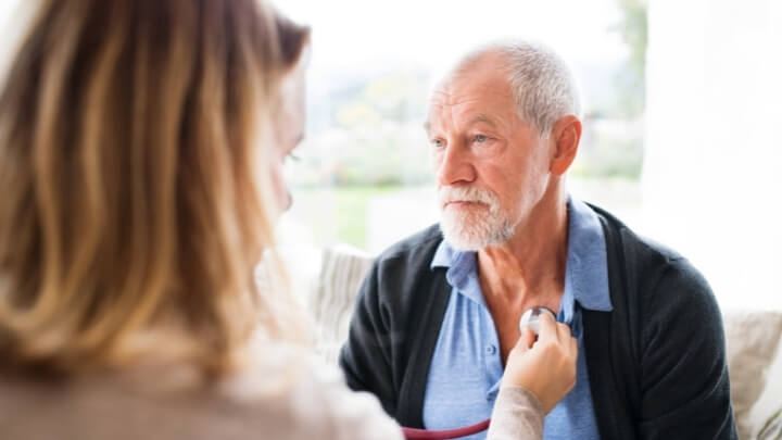 Doctor listening to a man's heart