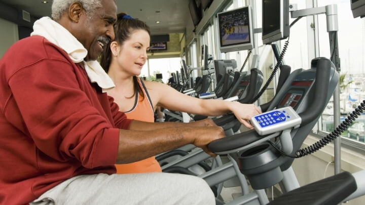 A personal trainer helping a senior man