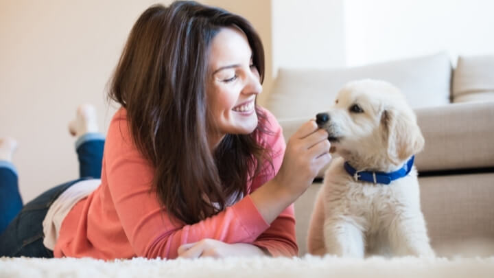 A woman giving a treat to her dog