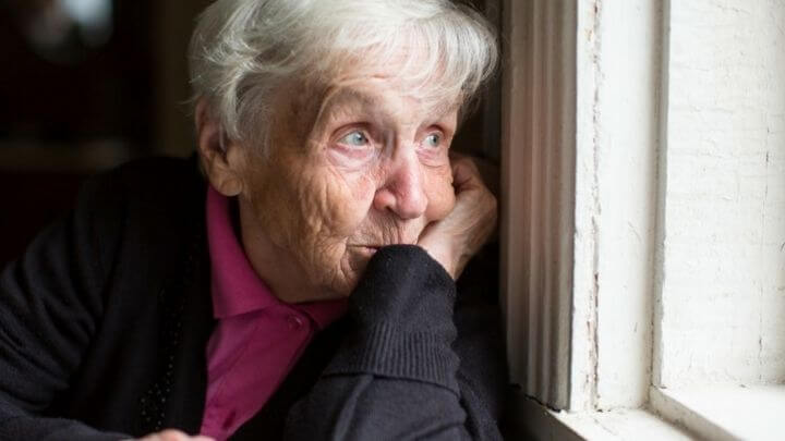 Older woman looking out of the window