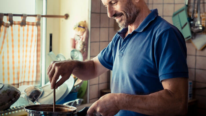 A happy man cooking at home