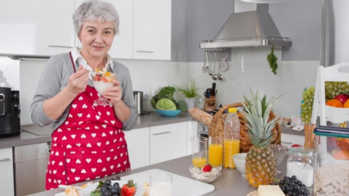 A woman is having a bowl of yogurt with fruits