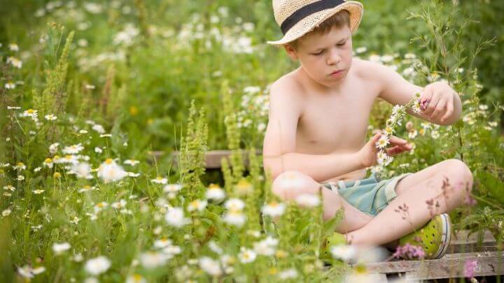 Boy playing with flowers in the nature