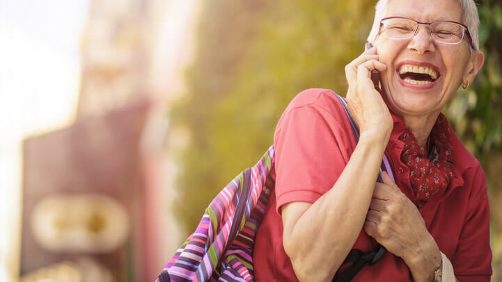 Older woman laughing while talking over the phone