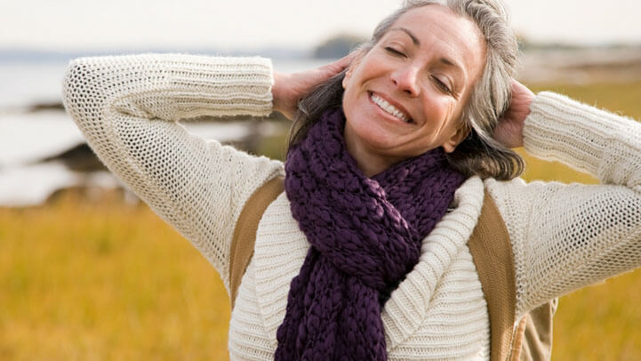 A happy woman hiking by a coastal line