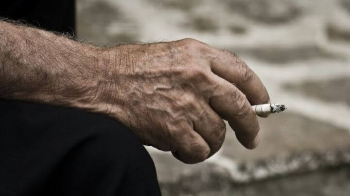 Older man's hand holding cigarette