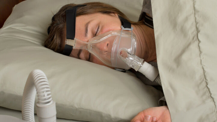 A woman sleeping with CPAP machine on