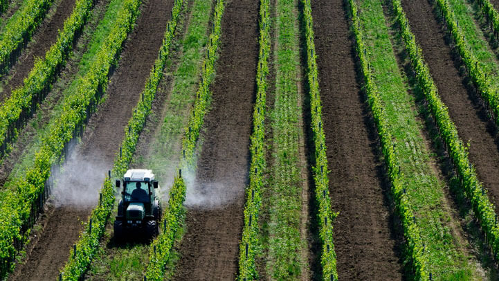 A tractor spraying pesticide on a field