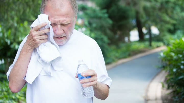 A sweaty senior man after exercise with a bottle of water