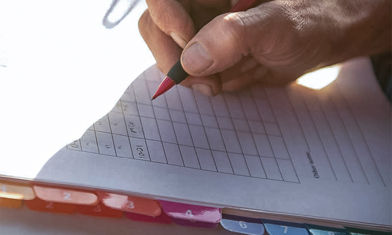 Grower recording notes in a field planning notebook