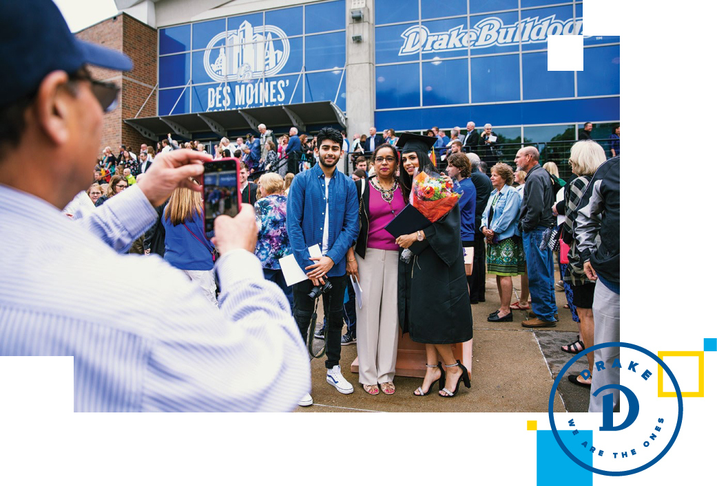 New Drake alumni with family outside Knapp Center after graduation