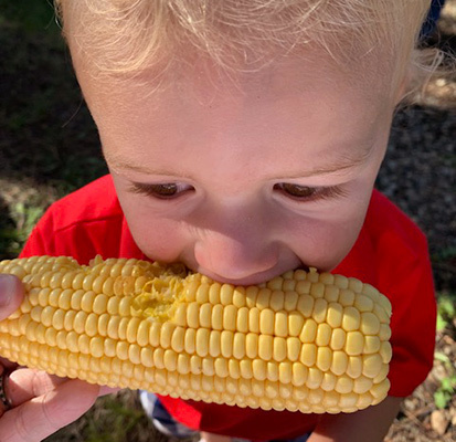 Boy eating corn Sized IMG 2045