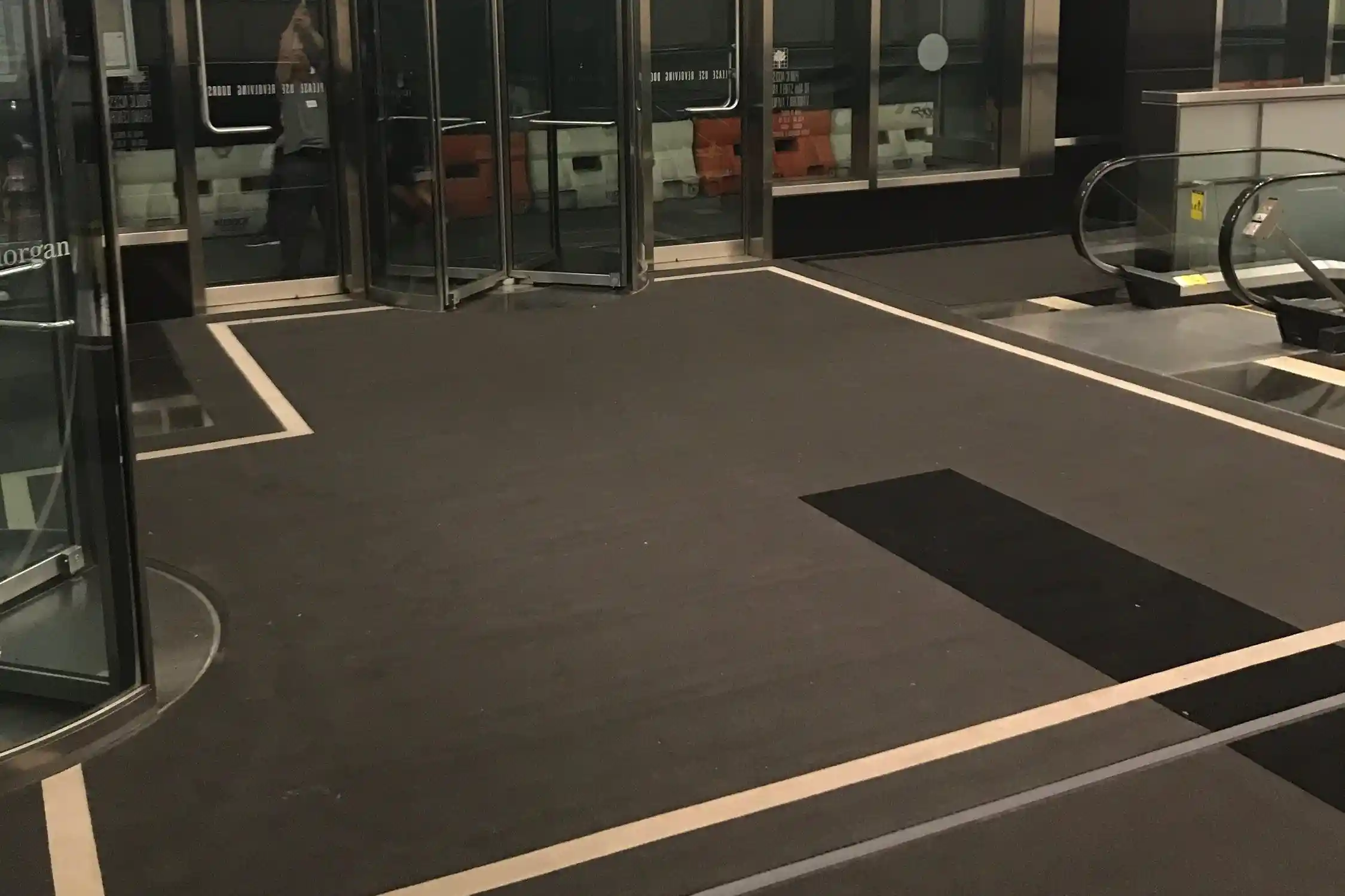 Matting by Design custom charcoal entrance mat with white borders in a commercial lobby.