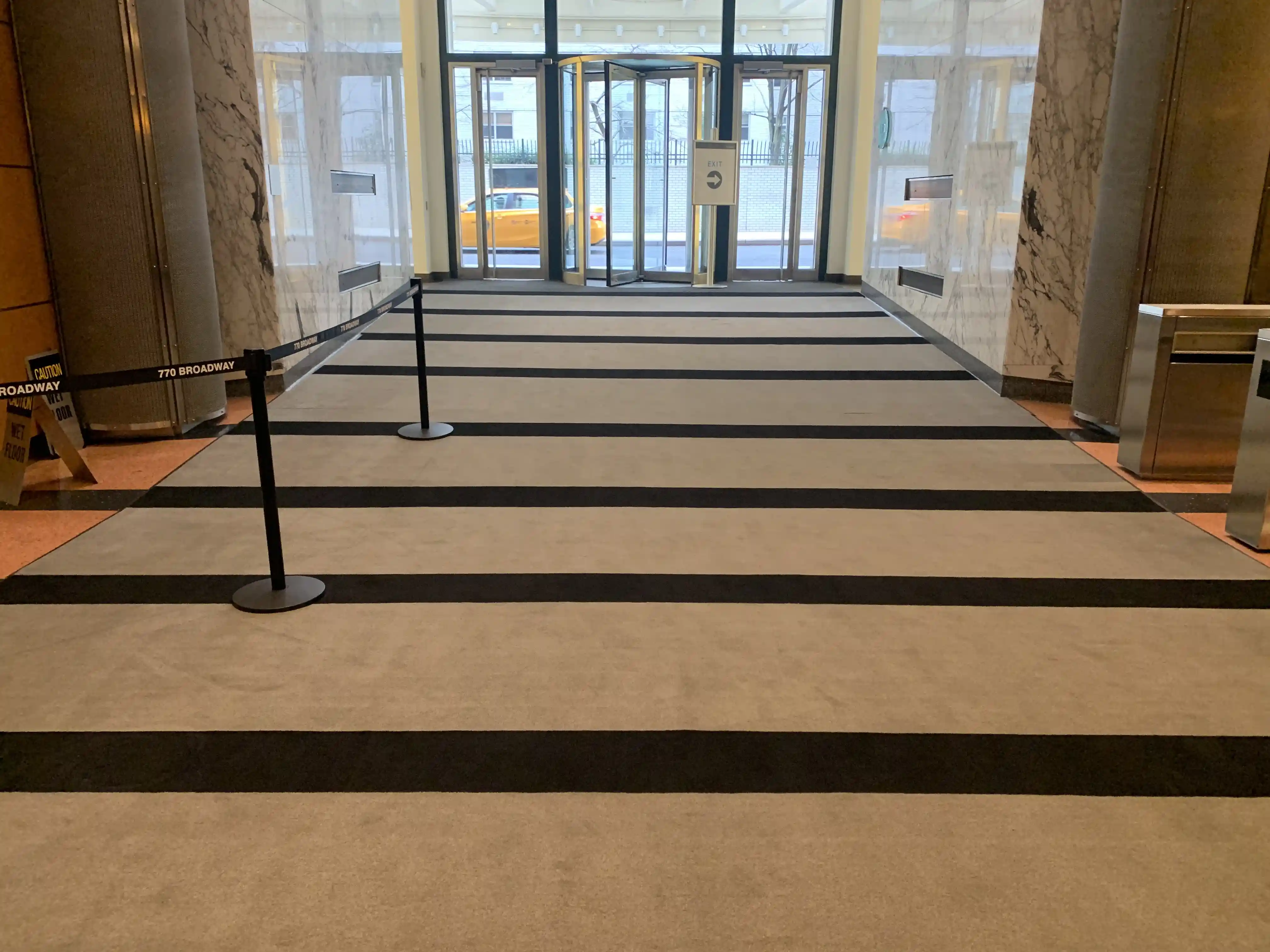 Matting by Design striped entrance mat in a commercial building lobby.