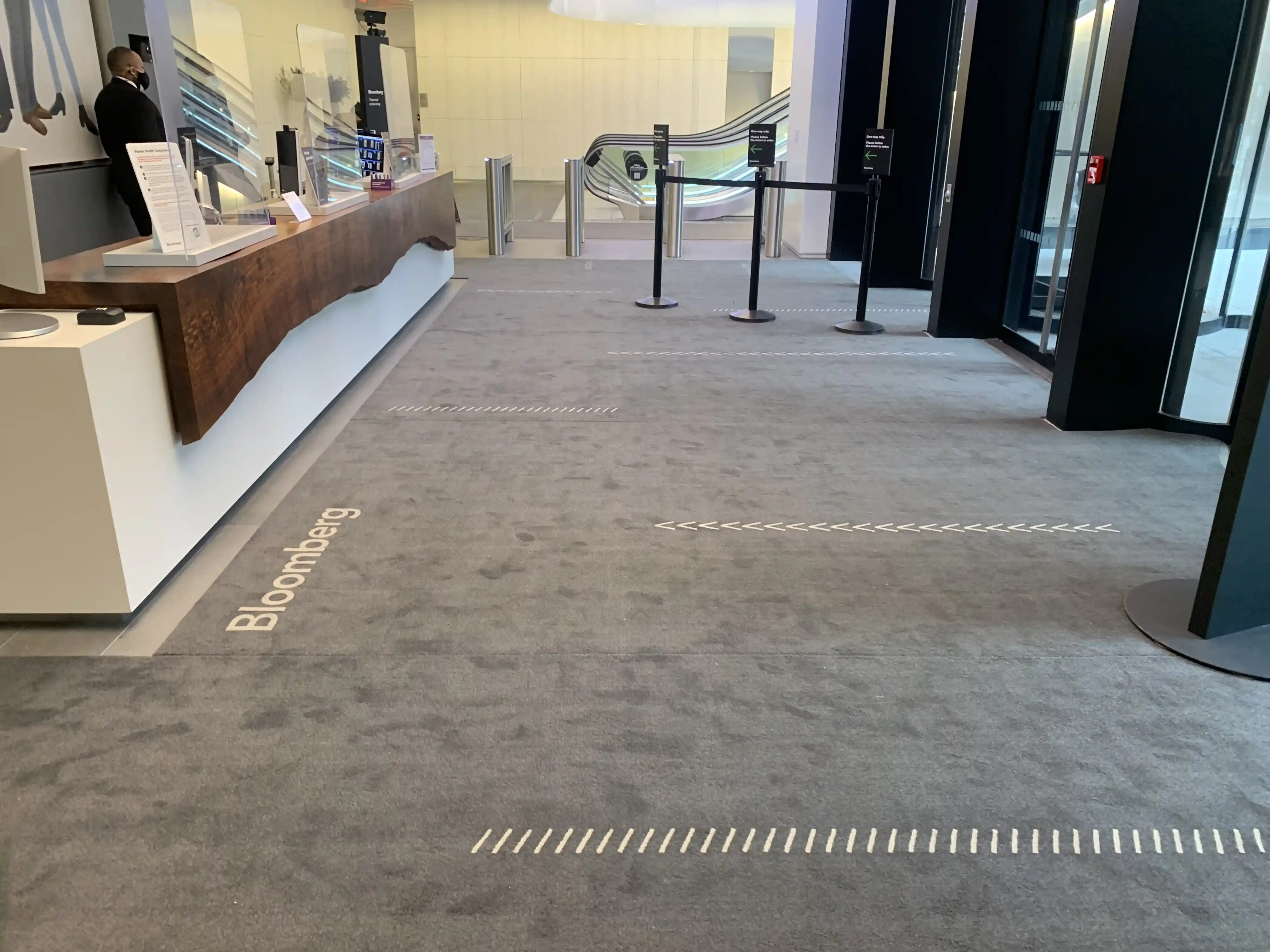 Matting by Design custom Bloomberg logo floor mat at a building entrance reception desk.