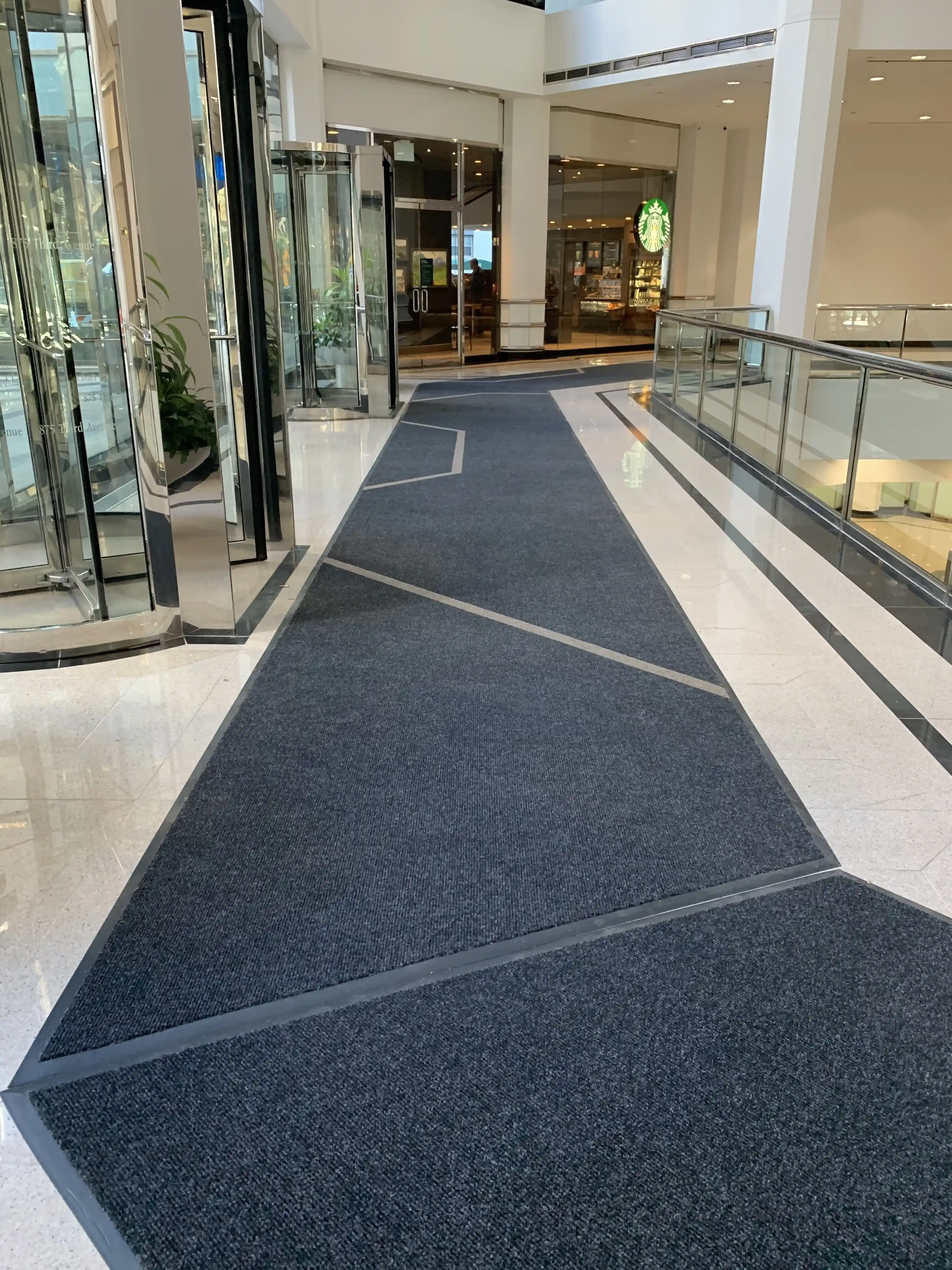 Matting by Design custom charcoal grey floor mats installed in a commercial lobby walkway.