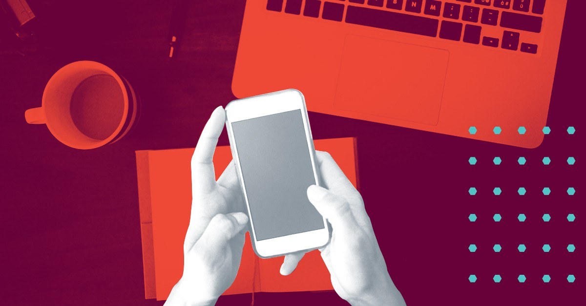 closeup of hands holding a smartphone at work desk