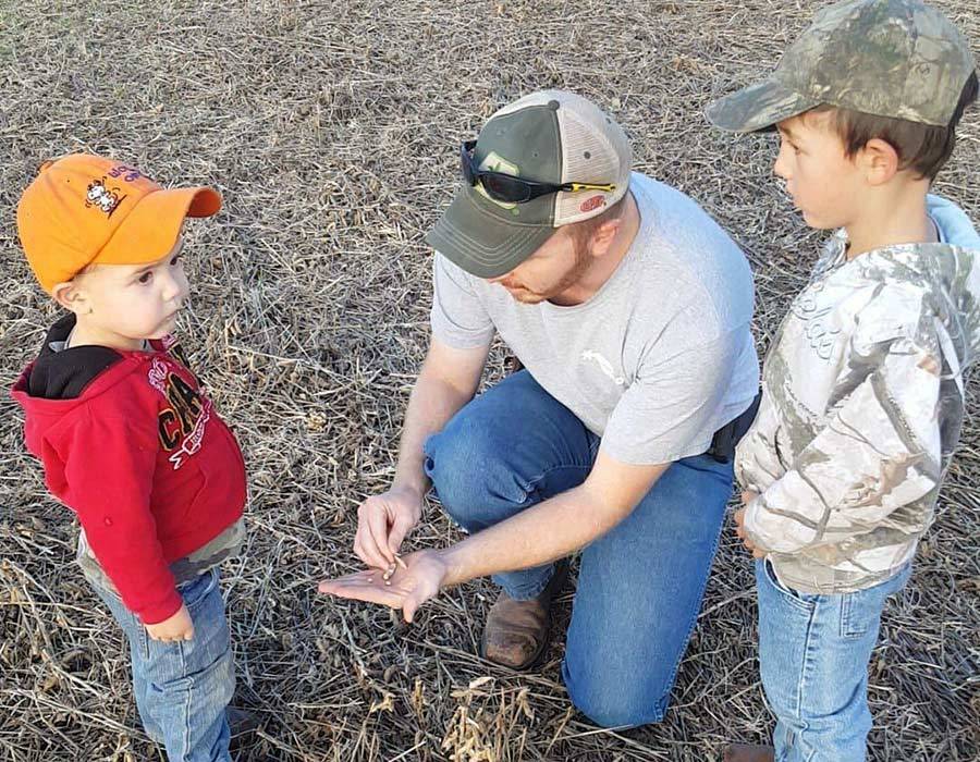 Agronomic Support Image Rylan in field with kids 900