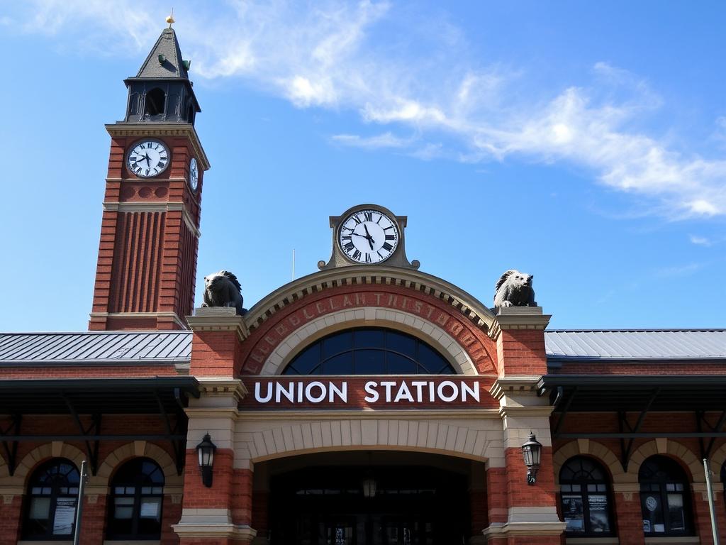 The iconic Union Station in Waterbury with its impressive clock tower and she-wolf gargoyles visible against a blue sky