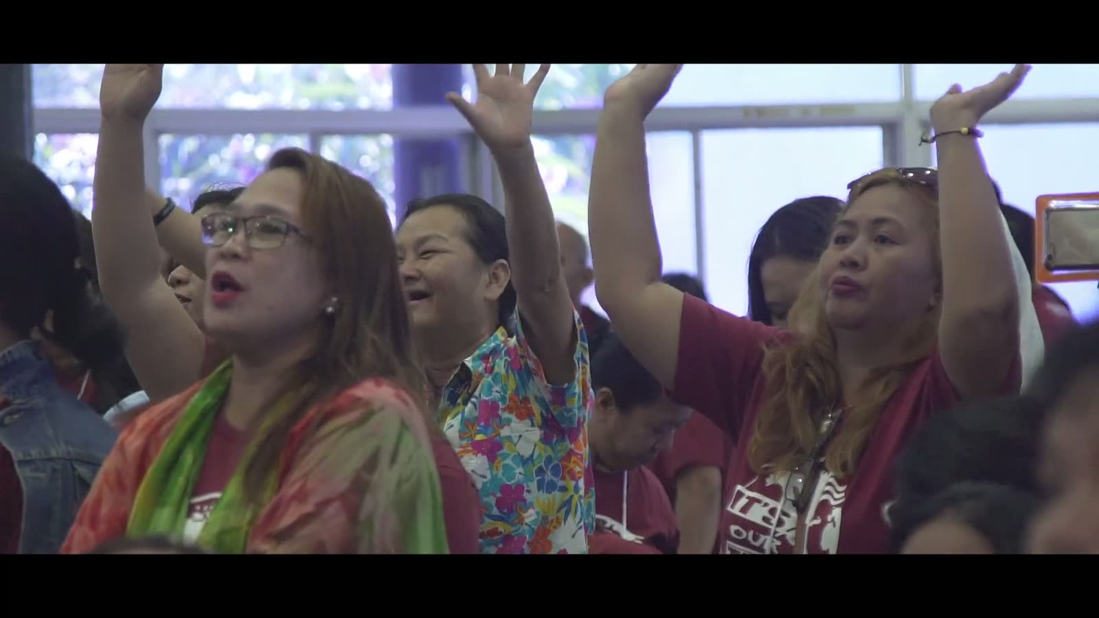 Filipino believers worshipping with hands raised