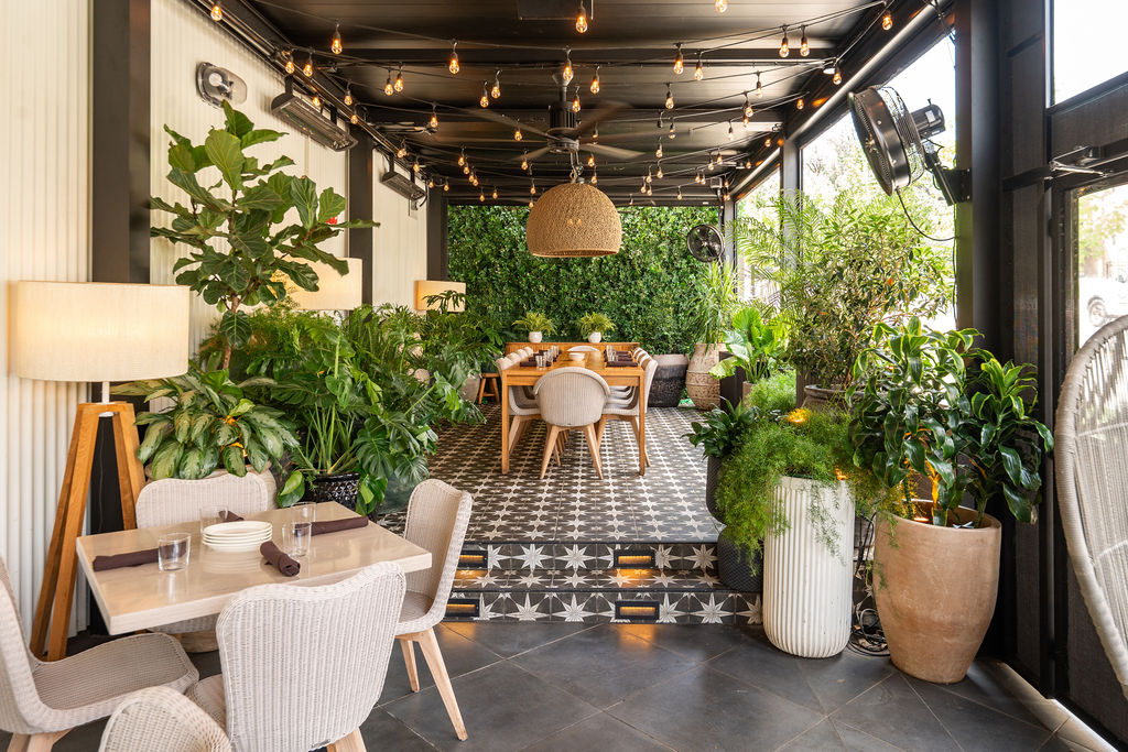 the patio at Aba with tables and greenery