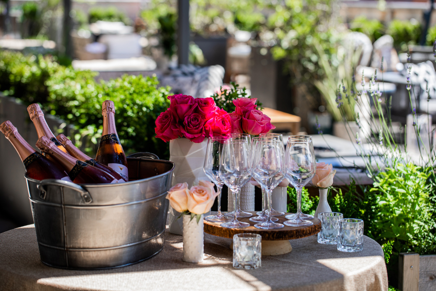 bottles of rose and wine glasses arranged on the patio table