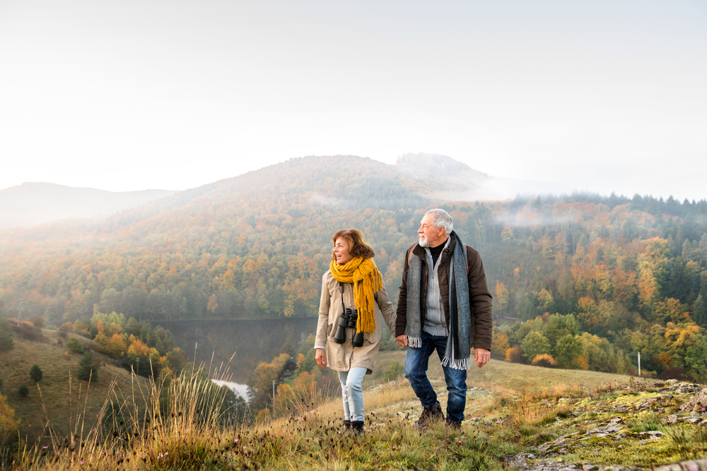 A senior couple walking in the mountains during the fall