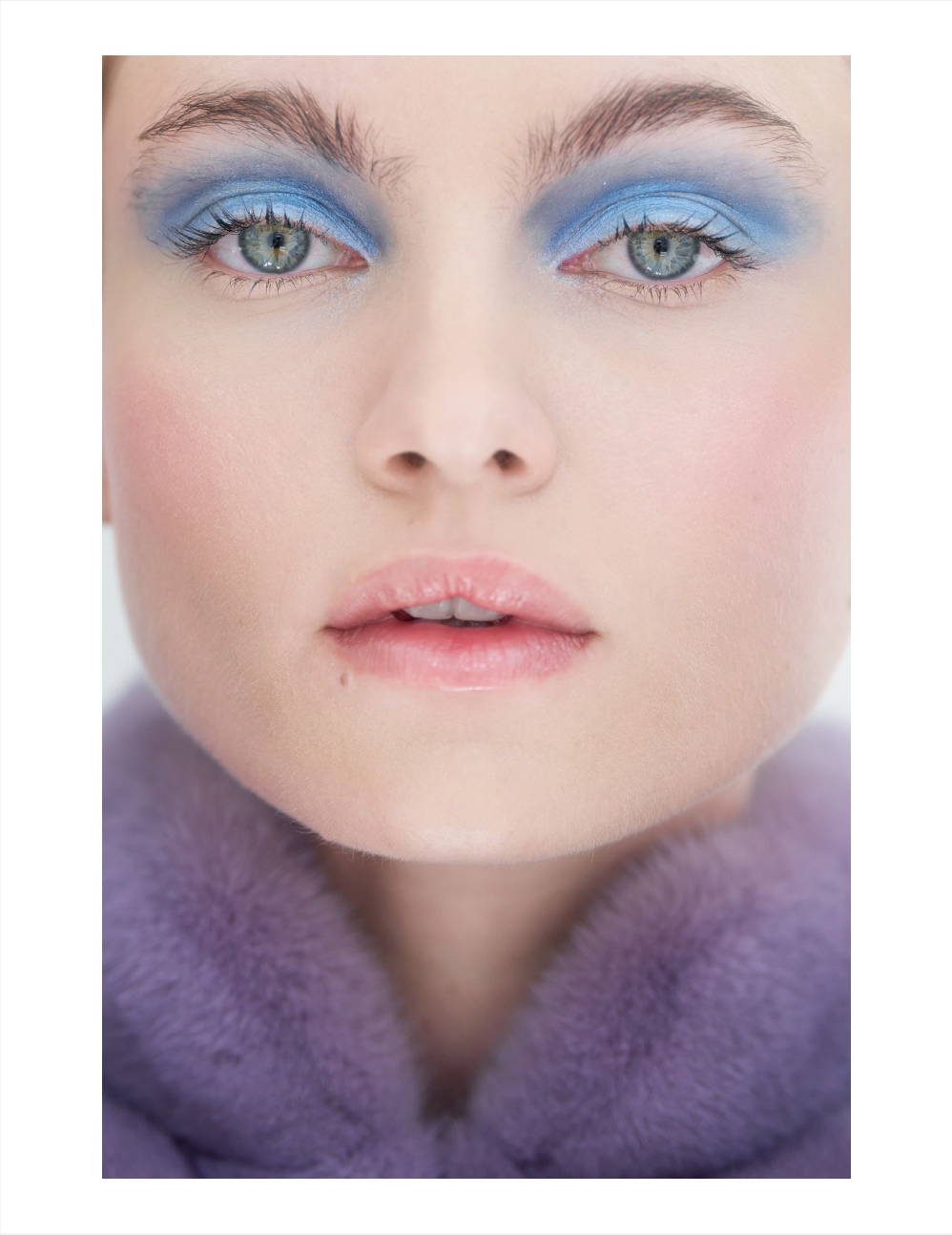 Close up of Anna wearing blue eyeshadow and a purple fur scarf