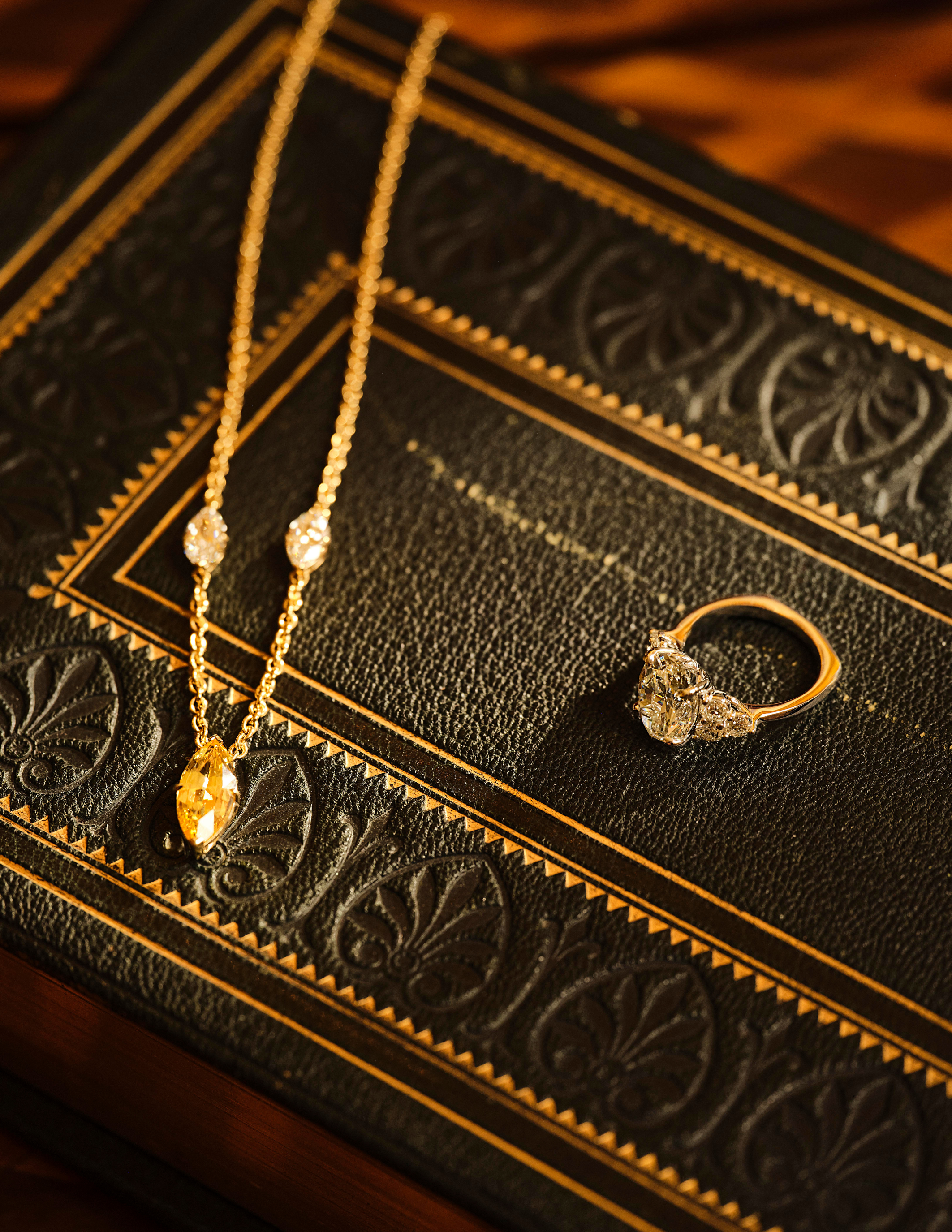 Avermore necklace and ring atop a vintage book with dramatic lighting