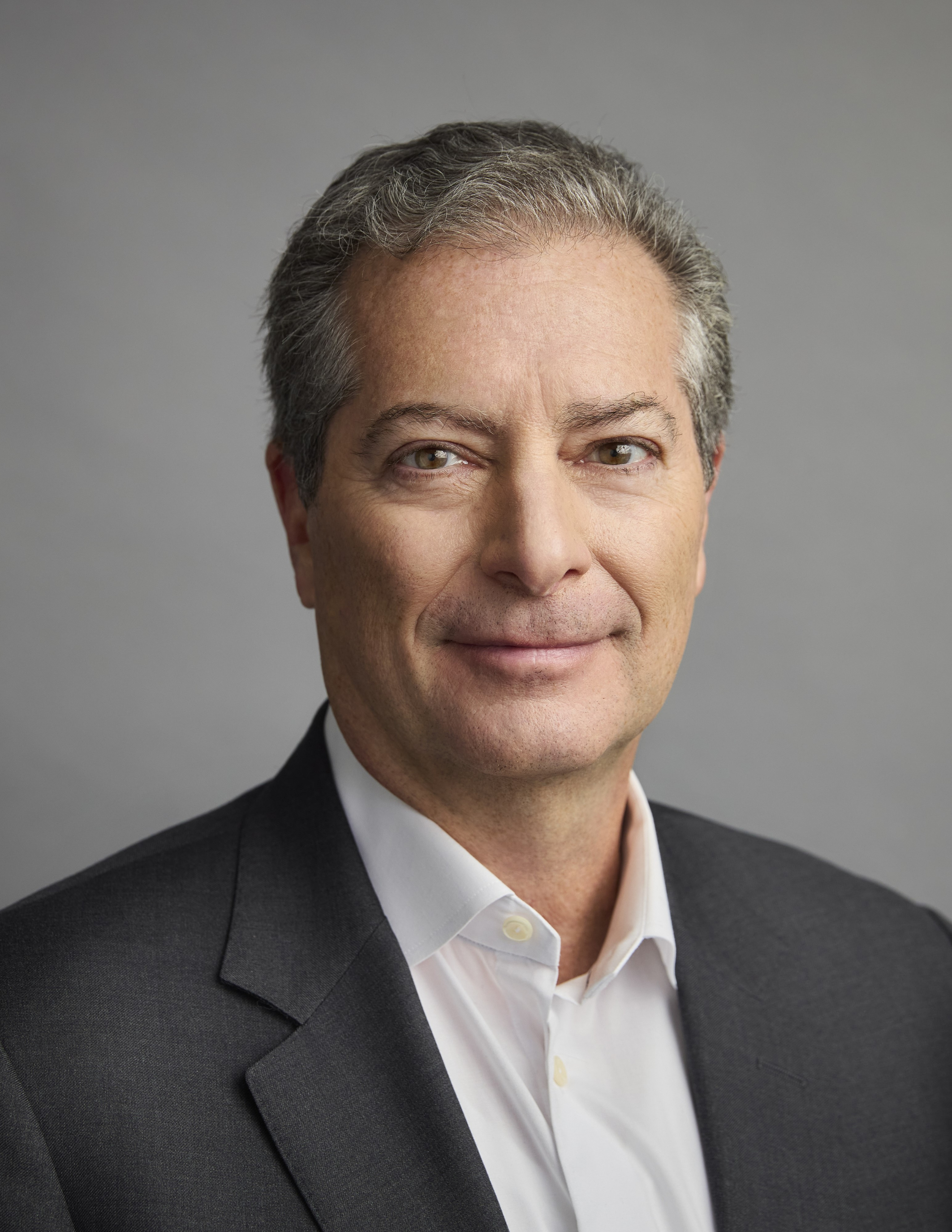 Professional headshot of Todd Kahn wearing a gray suit jacket and white shirt.