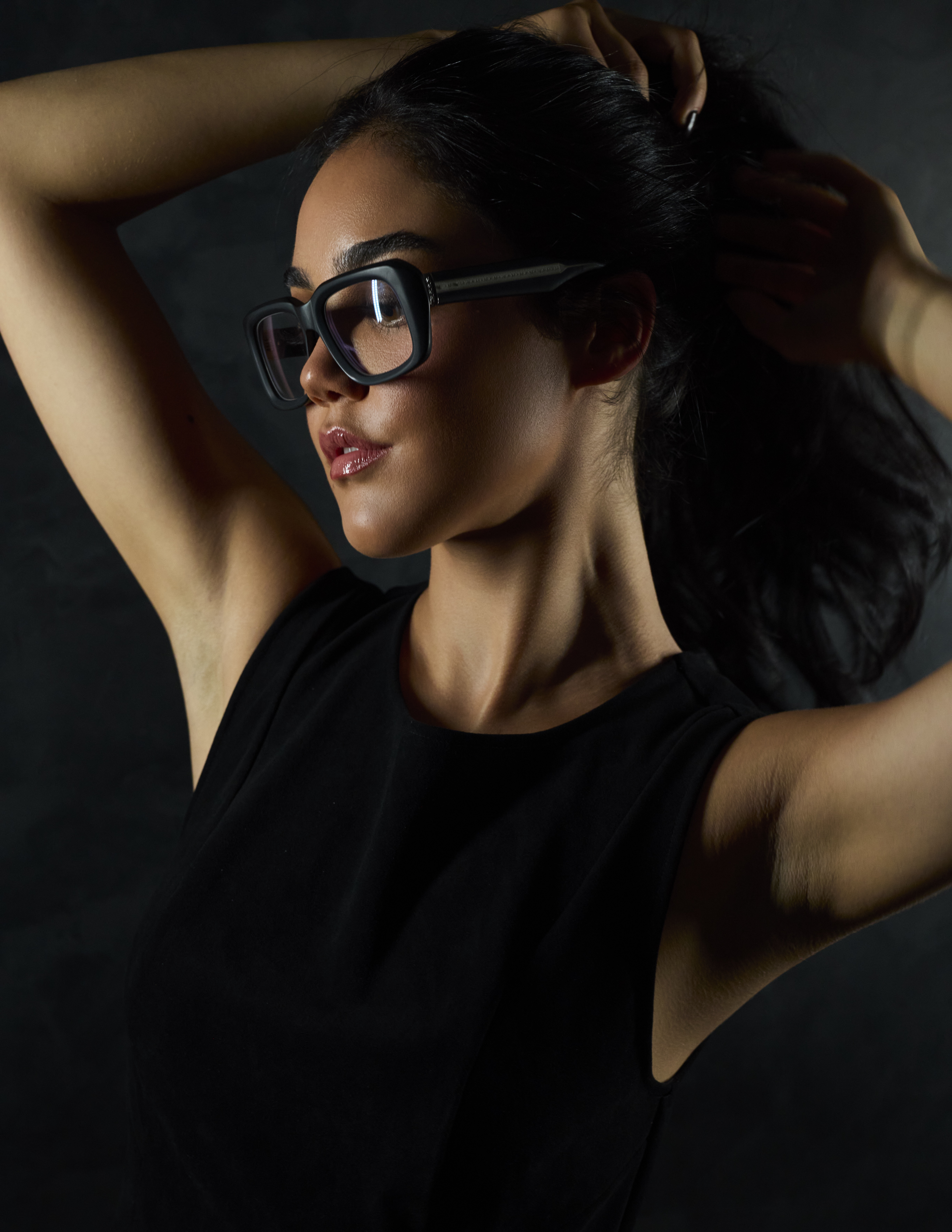 Model Catarina Milred wearing a black top and Matsuda eyewear on a black backdrop with dramatic lighting